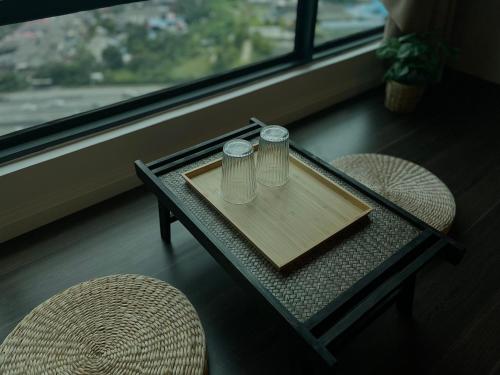 a glass table with two drinking glasses on top of it at Greenfield Residence, Bandar Sunway by The Comfort Zone in Petaling Jaya