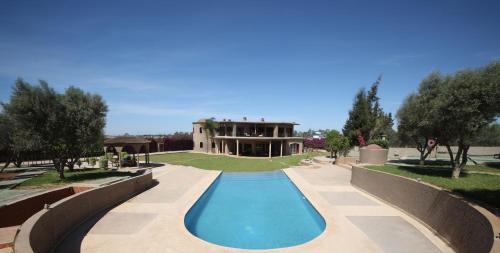 una piscina di fronte a una casa di Villa Tizra - guest house a AÃ¯n el Ksob