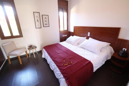 a bedroom with a large bed with a red blanket at Villa Tizra - Guest house in AÃ¯n el Ksob