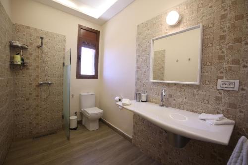 a bathroom with a sink and a toilet and a mirror at Villa Tizra - Guest house in AÃ¯n el Ksob