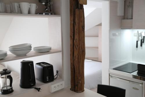 une cuisine aux murs blancs et un comptoir avec des appareils électroménagers dans l'établissement Le cocon perché entre l'Opéra et les Tuileries, à Paris