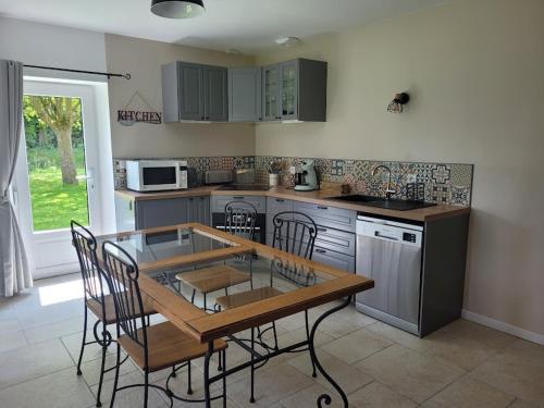 une cuisine avec une table et des chaises dans une cuisine dans l'établissement Location maison proche mer, à Canville-les-Deux-Églises