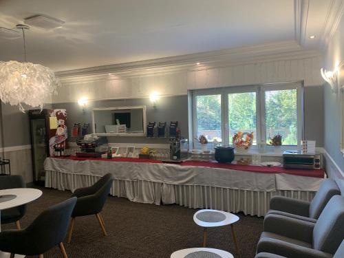 a waiting room with a table with chairs and a large window at Wellness Hotel Bahenec in Bahenec