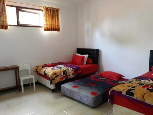 a room with two beds and a couch in it at Dannu's Homestay Ijen and Bromo Tour in Banyuwangi