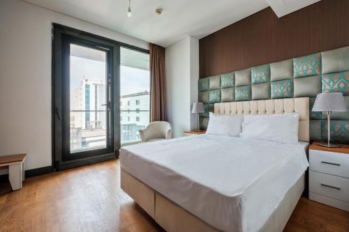 a bedroom with a large bed and a large window at Studio with City View Balcony 2 min to Metro in Istanbul