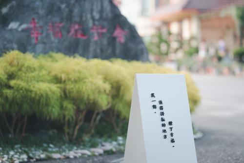 a sign that is next to some bushes at XinFu Traveler Inn in Taiping
