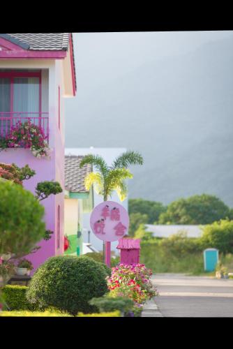 a street sign in front of a pink house at XinFu Traveler Inn in Taiping