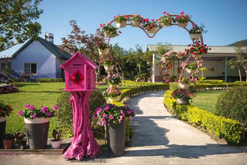 a pink bird house in a garden with flowers at XinFu Traveler Inn in Taiping