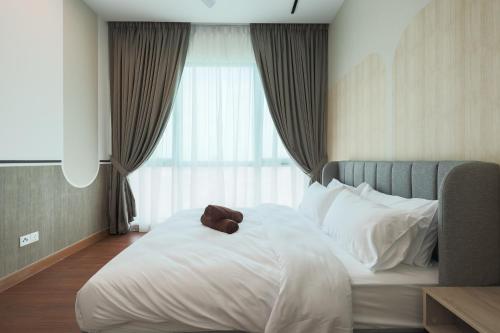 a bed with a brown teddy bear on top of it at Greenfield Residence, Bandar Sunway by The Comfort Zone in Petaling Jaya