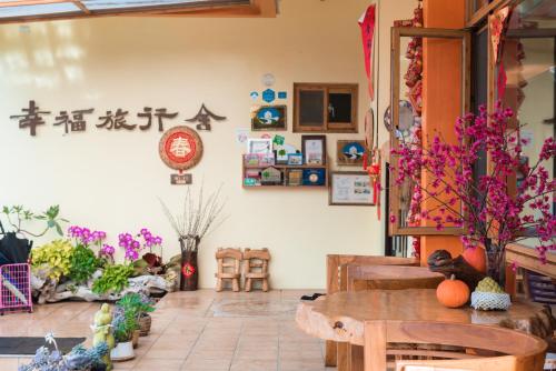 a room with a table and chairs and flowers at XinFu Traveler Inn in Taiping