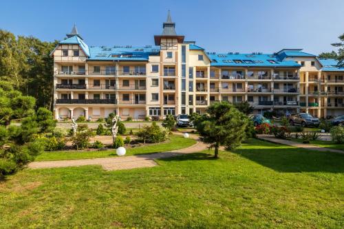 a large building with a park in front of it at Spokojny Apartament blisko Plaży - Spacerowa - by Renters in Łukęcin