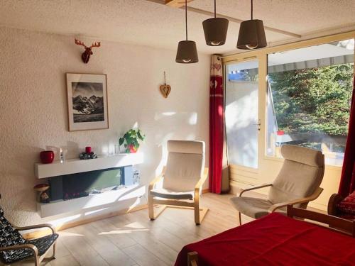 a living room with two chairs and a television at Serre chevalier,Chantemerle,T2 proche pistes in Saint-Chaffrey