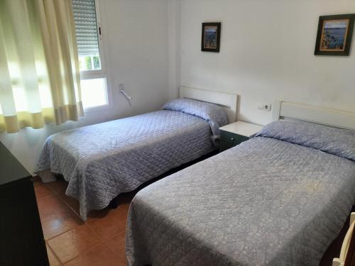 um quarto com 2 camas e uma janela em Sol y playa em Puçol