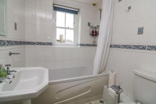 a bathroom with a tub and a sink and a toilet at 18 Robinsons Row in Salcombe