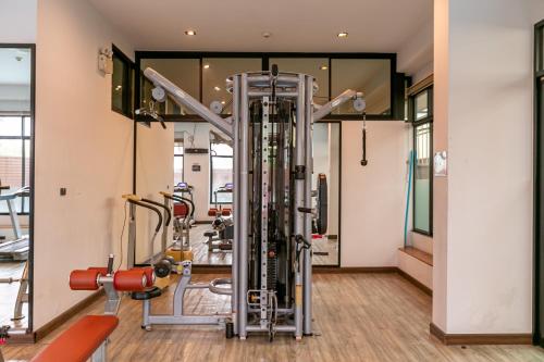 a gym with several treadmills and machines at Farthai Residence in Phan Thong