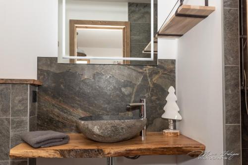 a bathroom with a stone sink and a mirror at Chalet Le Pourquoi Pas in La Bresse