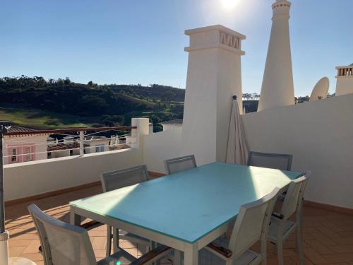 a blue table and chairs on a balcony with a lighthouse at Luxury private property-pool, unique sun roof, free wifi in Budens