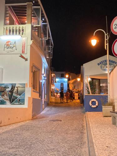 a street at night with people walking down the street at Luxury private property-pool, unique sun roof, free wifi in Budens