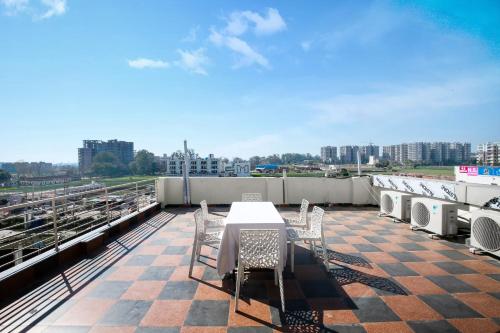 una mesa y sillas en la azotea de un edificio en Hotel Woodcrest Zirakpur - Real Meaning of Comfort, en Zirakpur