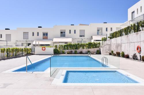 a swimming pool in the courtyard of a building at White Medano apartment. New with fast Wifi in El Médano