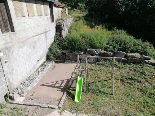 un jardín con un objeto verde en el césped junto a un edificio en LE MASSIF - Appartement avec vue imprenable, en La Bresse