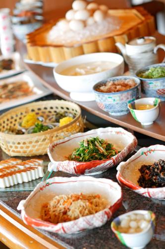 a buffet with bowls of food on a table at Hotel New Omi in Omihachiman