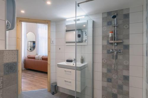 a bathroom with a sink and a glass shower at Budapest Design Condo by NW in Budapest