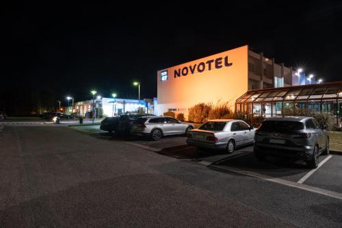 a dealership with cars parked in a parking lot at night at Novotel Chartres in Chartres