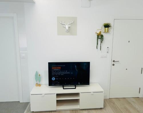 a living room with a tv on a white cabinet at SILVER -Apartamentos Birdie- in Albacete