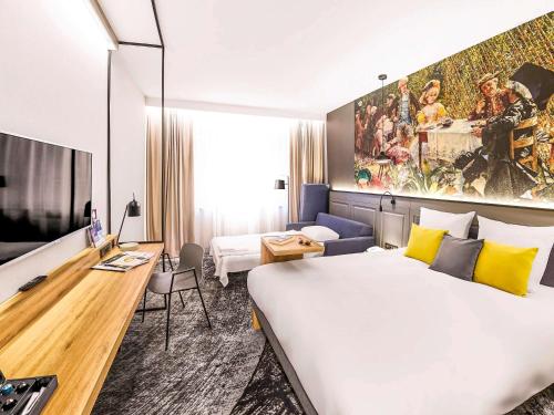 弗次瓦夫的住宿－弗羅茨瓦夫市中心美居酒店，酒店客房设有一张大床和一张书桌。
