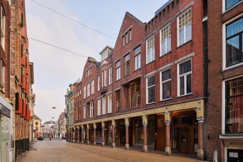an empty street in an old city with brick buildings at Business Guesthouse in Groningen