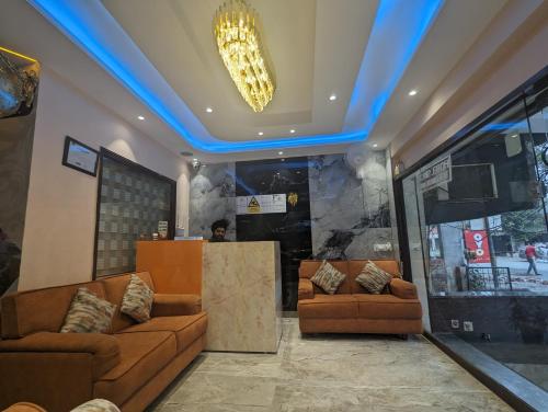 un vestíbulo con dos sofás marrones y una luz azul en Hotel Singh International, Amritsar, en Amritsar