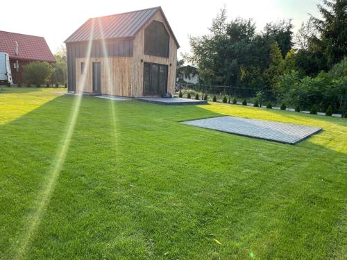 a house on a lawn with a solarium at Zielona Ostoja - domek z prywatnym pomostem przy Obrzycy in Kolsko