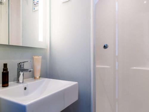 a white bathroom with a sink and a shower at Hotel ibis budget Chatillon Paris Ouest in Châtillon
