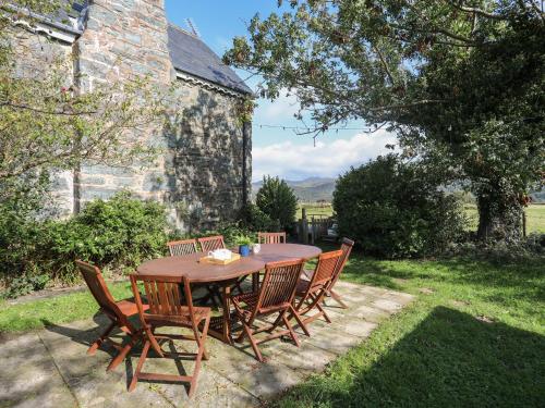 a wooden table and chairs in a yard at Glyn Morfa in Harlech