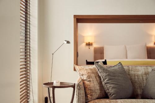 a bedroom with a bed and a couch and a mirror at Business Guesthouse in Groningen