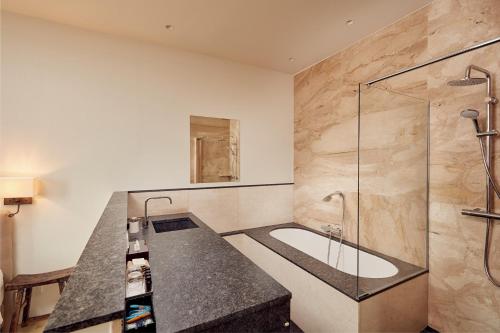 a bathroom with a shower and a sink and a tub at Business Guesthouse in Groningen