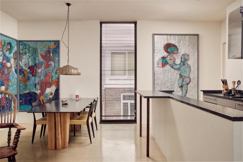 a kitchen and dining room with a table and a painting at Business Guesthouse in Groningen