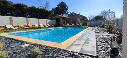 - une piscine dans une cour avec des chaises dans l'établissement Le Mas, à Saint-Sauveur-de-Cruzières