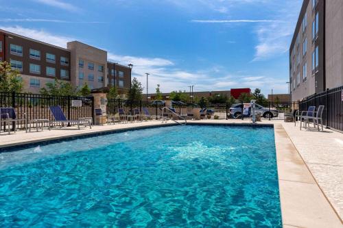 een groot zwembad met stoelen in een gebouw bij Hawthorn Extended Stay by Wyndham Pflugerville in Pflugerville