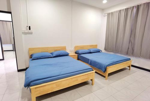 two beds with blue pillows in a room at 3 mins to Garden City & Kubota Jln Chong Thien Vun in Tawau