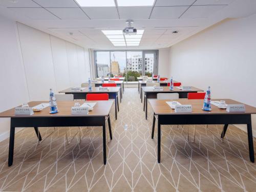 a room with tables and chairs with water bottles on them at Mercure Alger Palais Des Congres in Alger