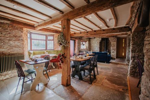 una sala de estar con techos de madera, mesas y sillas en Hanley House, en Tenbury