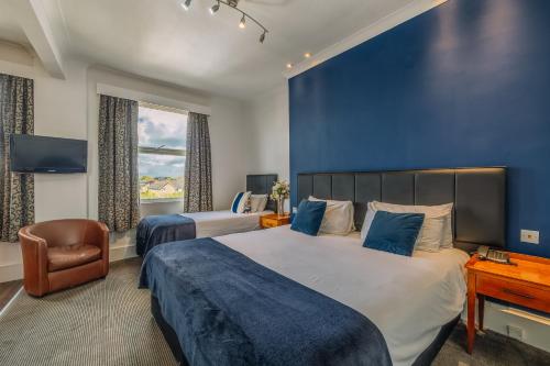 a bedroom with two beds and a blue wall at Muthu Westcliff Hotel (Near London Southend Airport) in Southend-on-Sea