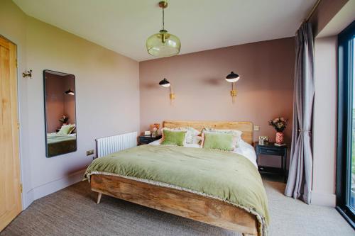 a bedroom with a large bed with green pillows at Hanley House in Tenbury