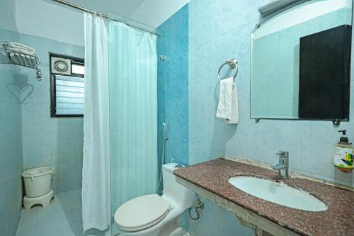 a blue bathroom with a toilet and a sink at The Park Classic Udaipur in Udaipur