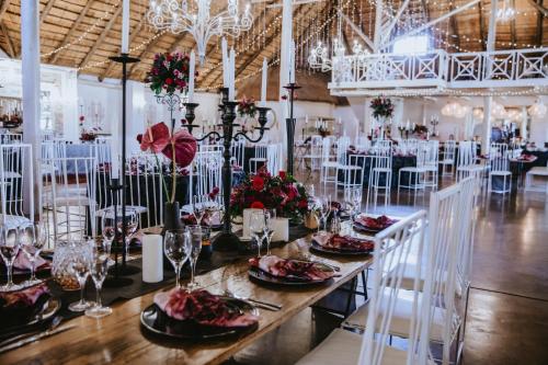 a dining room with a long table and white chairs at Siesta Guesthouse & Wedding Venue - Frankfort in Frankfort