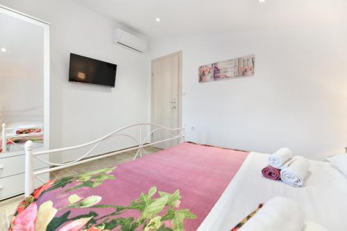a bedroom with a bed and a tv on a wall at Villa Bella in Kruševo