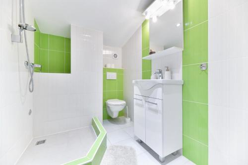 a bathroom with a sink and a toilet and green tiles at Villa Bella in Kruševo