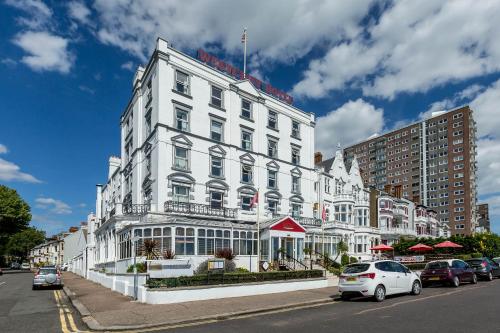 ein weißes Gebäude mit davor geparkt in der Unterkunft Muthu Westcliff Hotel (Near London Southend Airport) in Southend-on-Sea